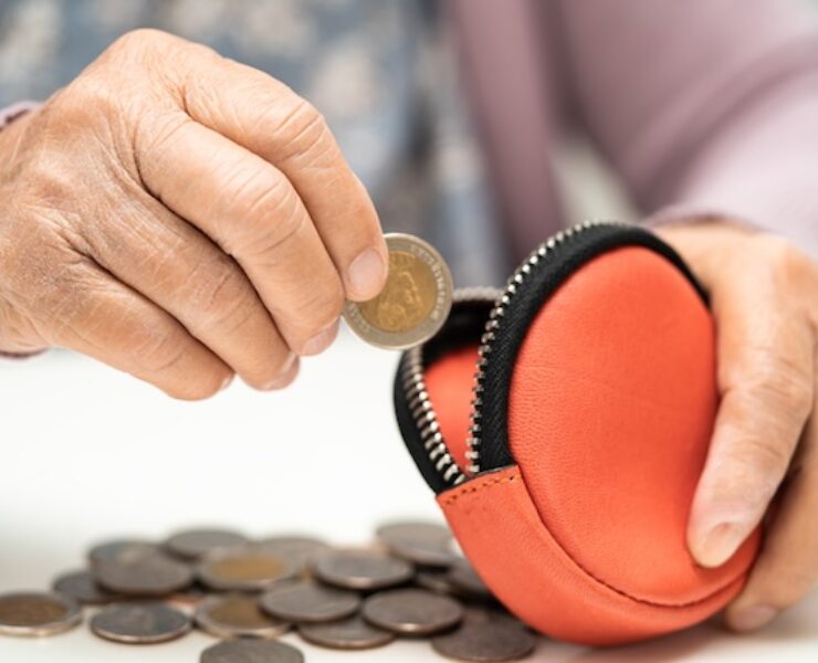 Asian senior woman holding counting coin money in purse. Poverty, saving problem in retirement.